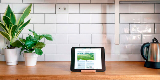 リフォームされたおしゃれなキッチンと新しいWebサイトが表示されたタブレット